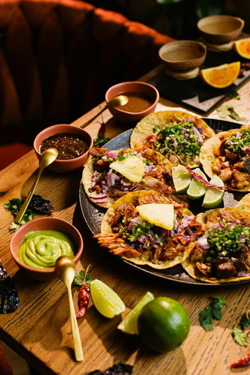 Tacos acompañados de salsas y limones