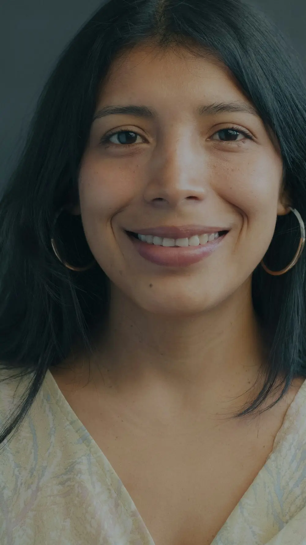 Mujer sonriendo con aretes de aro
